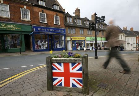 A man walks past a planter decorated with the union flag in Coleshill, central England, March 31, 2015. At the 2010 general election, Dan Byles won the North Warwickshire seat by just 54 votes, making him the Conservative Member of Parliament with the smallest majority in the country. REUTERS/Darren Staples