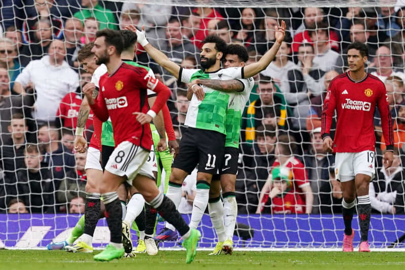 Liverpool's Mohamed Salah (C) celebrates scoring his side's second goal of the game during the English Emirates FA Cup quarter-final soccer match between Manchester United and Liverpool at Old Trafford. Martin Rickett/PA Wire/dpa