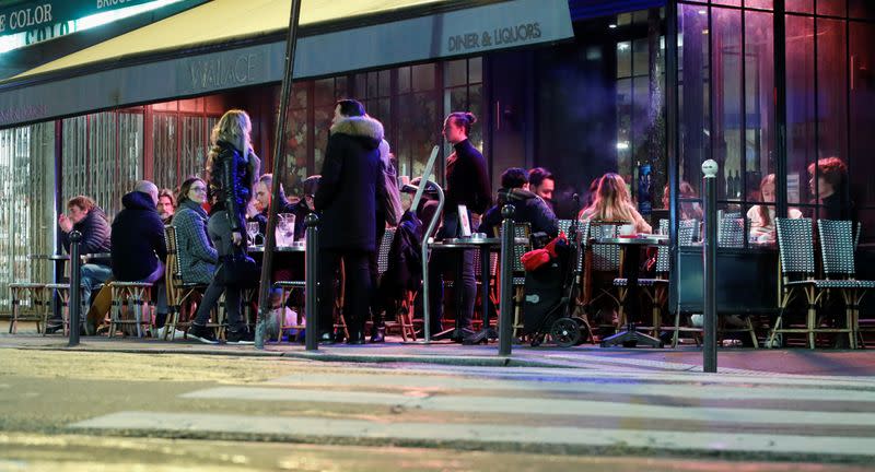 People sit in a outside restaurant, as France's Prime Minister announced to close most all non-indispensable locations, notably cafes, restaurants, cinemas, nightclubs and shops from midnight on Saturday, in Paris