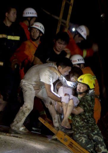 Chinese rescue workers carry an injured girl as they tend to the victims of a high-speed train accident, near Wenzhou. Emergency workers battled on Sunday to rescue survivors from the mangled wreckage of two Chinese bullet trains involved in a high-speed collision which left 33 dead and nearly 200 injured, reports said