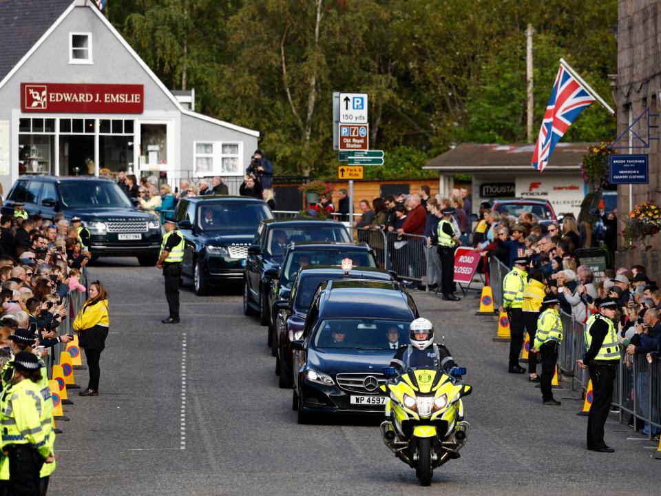 People line the streets to see the monarch's coffin pass through.