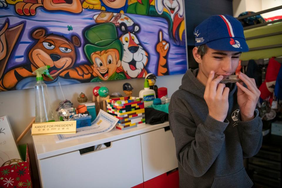 Isaac Rosenthal plays harmonica in his bedroom.