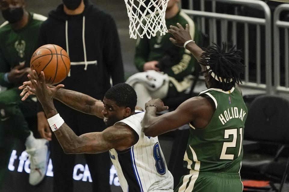 Orlando Magic's Dwayne Bacon tries to shoot past Milwaukee Bucks' Jrue Holiday during the second half of an NBA basketball game Tuesday, May 11, 2021, in Milwaukee. (AP Photo/Morry Gash)