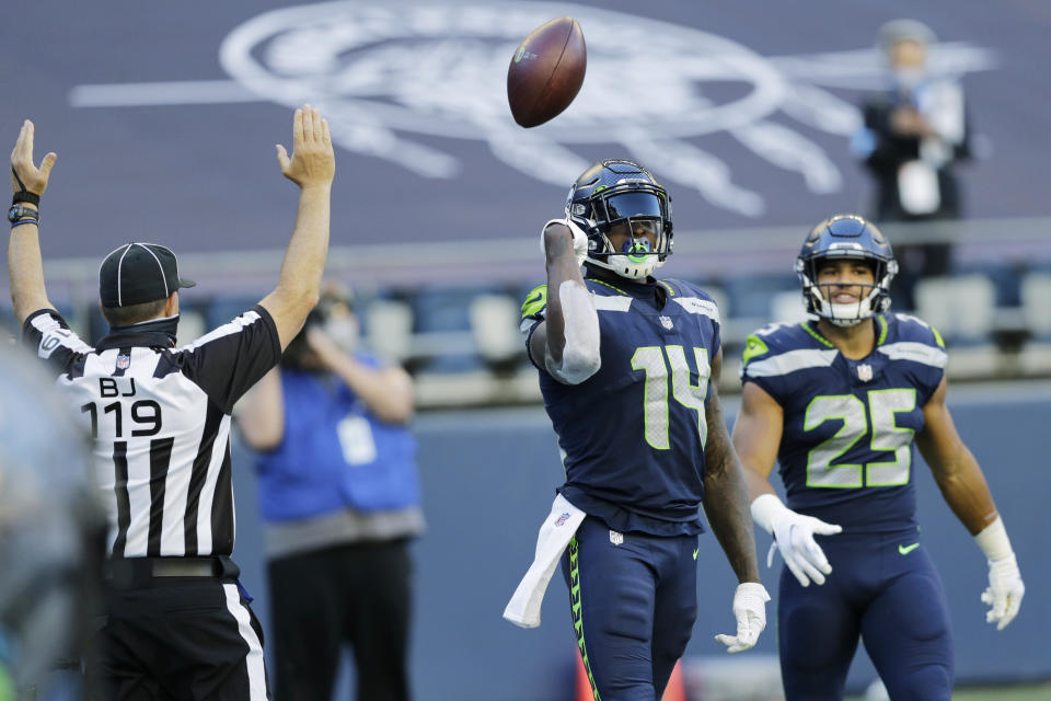 Seattle Seahawks wide receiver DK Metcalf (14) tosses the ball as he stands with running back Travis Homer (25) after Metcalf scored a touchdown against the Dallas Cowboys during the second half of an NFL football game, Sunday, Sept. 27, 2020, in Seattle. (AP Photo/John Froschauer)