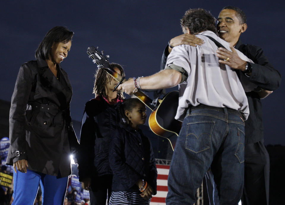 FILE - In this Nov. 2, 2008, file photo Democratic presidential candidate Sen. Barack Obama, D-Ill., on stage with his wife Michelle Obama and daughters Malia and Sasha, hugs Bruce Springsteen at a rally at the Cleveland Mall, in Cleveland, Ohio. Springsteen is hitting the campaign trail again on President Barack Obama's behalf, and he'll be joined this time by former President Bill Clinton at a rally in Parma, Ohio, on Thursday, Oct. 18, 2012. (AP Photo/Alex Brandon, File)