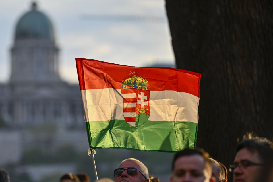 A man holds a Hungarian flag during protest outside the Hungarian Interior Ministry building to demand stronger protections for children and Interior minister Sandor Pinter to step down, in Budapest, Hungary, Friday, April 26, 2024. Peter Magyar, a former insider within Orban's ruling Fidesz party, lead a protest. The demonstration was the latest in a series of large anti-government protests that Magyar has mobilized in recent weeks, and comes as the political newcomer is campaigning for EU elections this June with his new party, Respect and Freedom (TISZA). (AP Photo/Denes Erdos)