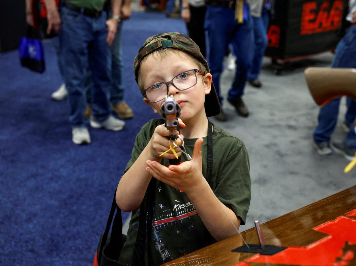 Hudson Eckart, 6, from Indiana, tries out a gun during the National Rifle Association (NRA) annual convention.