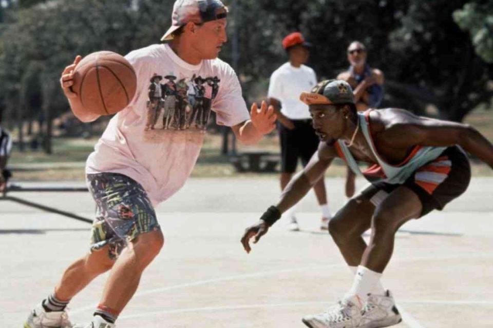 Woody Harrelson dribbling the basketball around Wesley Snipes