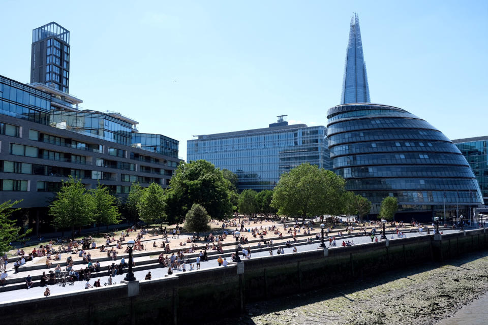 The Shard and the City hall are seen as people enjoy the hot weather on the bank of the River Thames in London, following the outbreak of the coronavirus disease (COVID-19), London, Britain, May 31, 2020. REUTERS/Steven Watt
