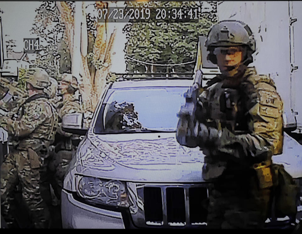 In this image made from a Monday, July 29, 2019, security camera video provided by a neighbor who has requested not to be identified, federal agents conduct a raid on the home of Paige A. Thompson in Seattle. Thompson is accused of accessing the personal information of millions of Capital One credit card holders or credit card applicants in the U.S. and Canada. The time and date stamp on the image is inaccurate, as the raid took place on Monday, July 29, 2019. (Courtesy Photo via AP)