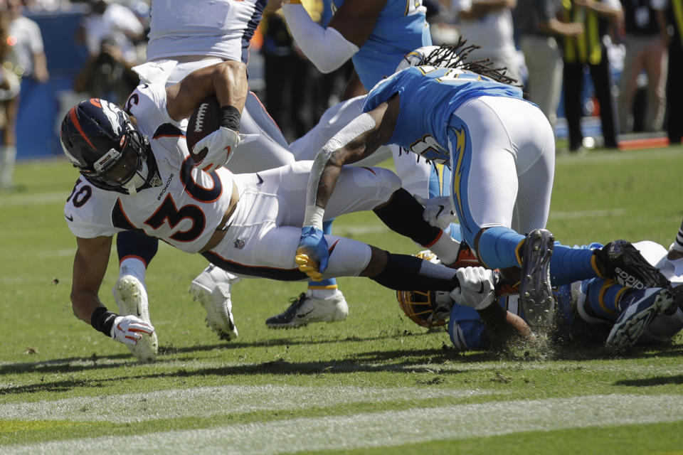 Denver Broncos running back Phillip Lindsay scores past Los Angeles Chargers defensive back Rayshawn Jenkins during the first half of an NFL football game Sunday, Oct. 6, 2019, in Carson, Calif. (AP Photo/Marcio Jose Sanchez)