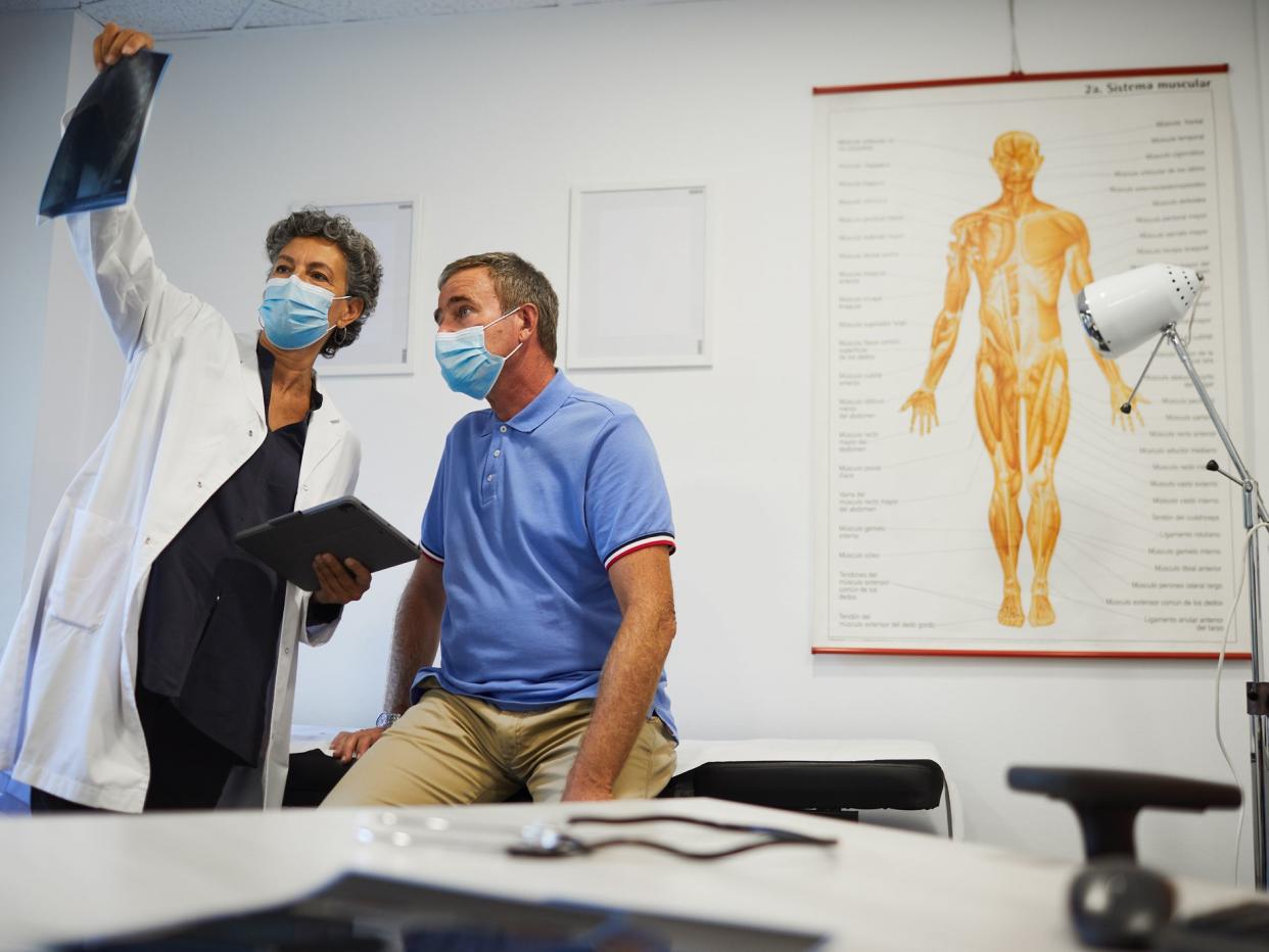 Medical office A female doctor and a patient looking at a X-ray