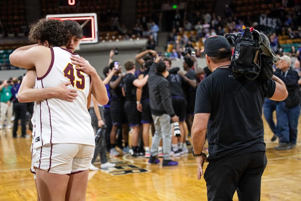 Windsor teammates embrace while Mesa Ridge celebrates after a close class 5A state championship game against Mesa Ridge at the Denver Coliseum on Saturday.