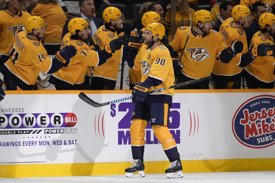Nashville Predators center Ryan O'Reilly (90) celebrates a goal with teammates during the first period of an NHL hockey game against the New Jersey Devils, Tuesday, Feb. 13, 2024, in Nashville, Tenn. (AP Photo/George Walker IV)