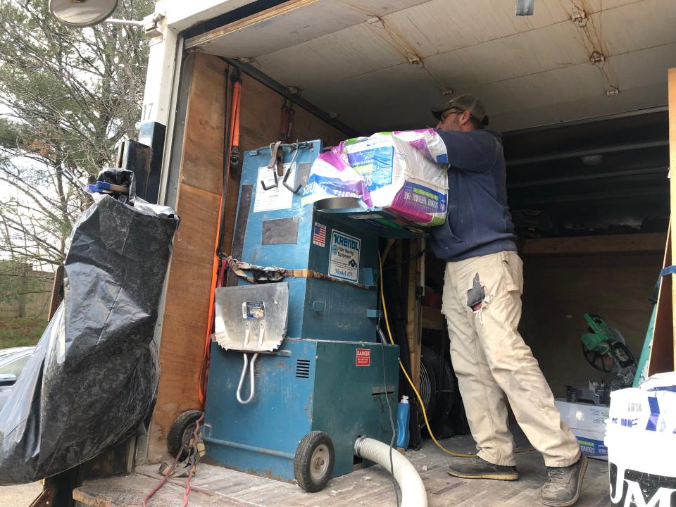 A Tioga Opportunities employee fills a machine with insulation that will insulate the walls of a home at 125 West St. in Johnson City.