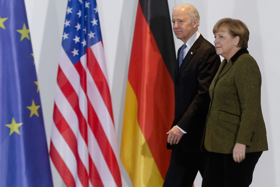 ARCHIVO - En esta foto del 1 de febrero del 2013, la canciller alemana Angela Merkel camina con el entonces vicepresidente estadounidense Joe Biden en la cancillería en Berlín. (AP Foto/Markus Schreiber)