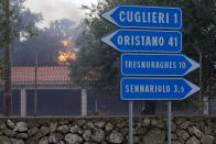 Fires rage through the countryside in Cuglieri, near Oristano, Sardinia, Italy, early Sunday, July 25, 2021. Hundreds of people were evacuated from their homes in many small towns in the province of Oristano, Sardinia, after raging fires burst in the areas of Montiferru and Bonarcado. (Alessandro Tocco/LaPresse via AP)