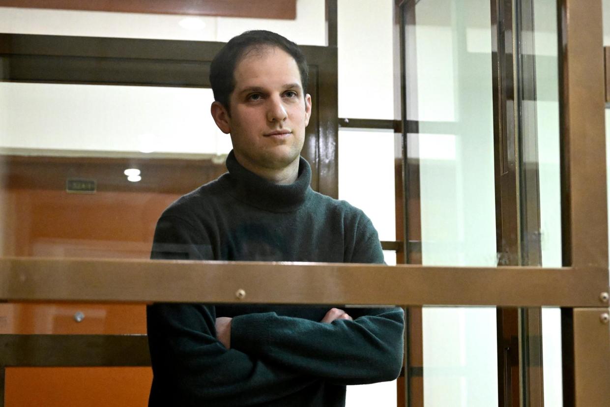 <span>The Wall Street Journal reporter Evan Gershkovich stands in a glass cage in a courtroom in Moscow on 14 December 2023.</span><span>Photograph: Dmitry Serebryakov/AP</span>