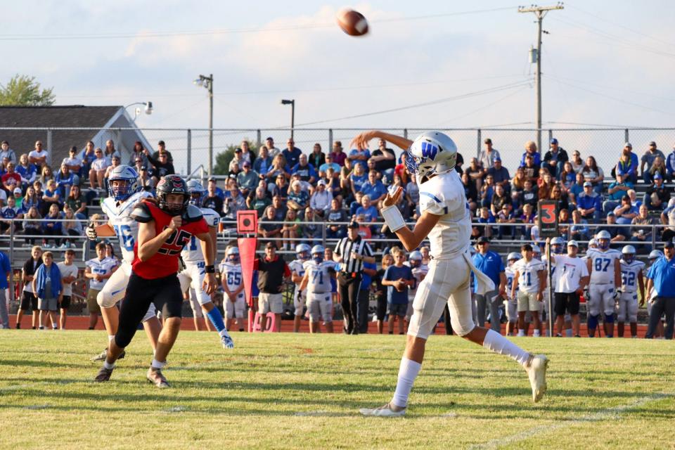 Wynford quarterback Ashton Warren attempts a pass at Pleasant with Nathan Wansik in pursuit during a game last season. Wansik finished with 85 tackles a year ago and is back for the Spartans.