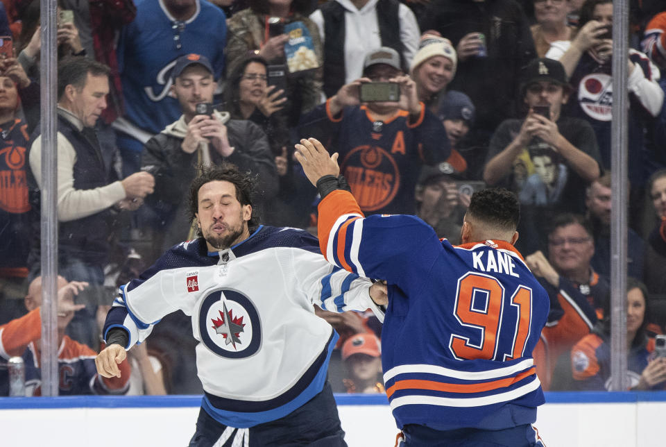 Winnipeg Jets' Brenden Dillon, left, and Edmonton Oilers' Evander Kane (91) fight during the second period of an NHL hockey game in Edmonton, Alberta, Saturday, Oct. 21, 2023. (Jason Franson/The Canadian Press via AP)