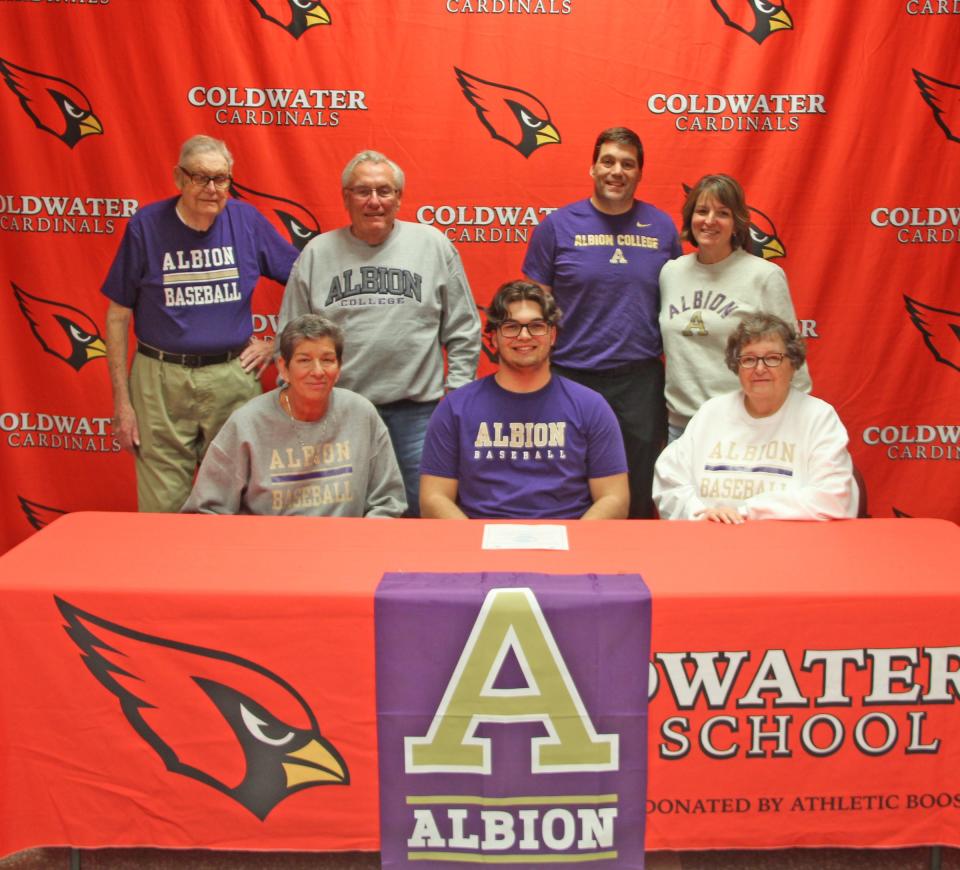 Coldwater's Logan Farmer (center) is surrounded by his family as he signs his letter of intent to play baseball at Albion College