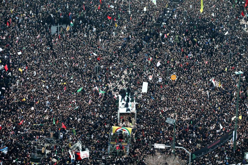 <span>Iranians gather around a vehicle carrying the coffins of slain major general Qasaem (Qasem) Soleimani and others as they pay homage in the northeastern city of Mashhad on January 5, 2020</span><div><span>MOHAMMAD TAGHI</span><span>TASNIM NEWS</span></div>