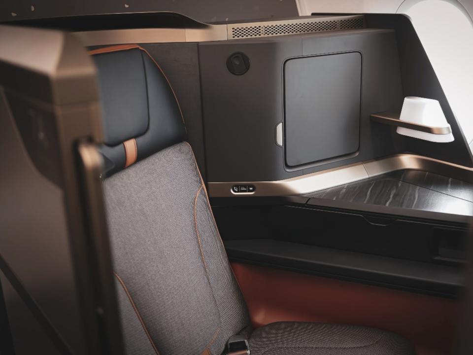 Starlux's business class seat with a side table, lamp, and cubby.