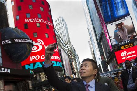 Weibo Corporation Chairman Charles Chao takes a photo during a visit to the NASDAQ MarketSite in Times Square in celebration of Weibo's initial public offering (IPO) on The NASDAQ Stock Market in New York April 17, 2014. REUTERS/Andrew Kelly