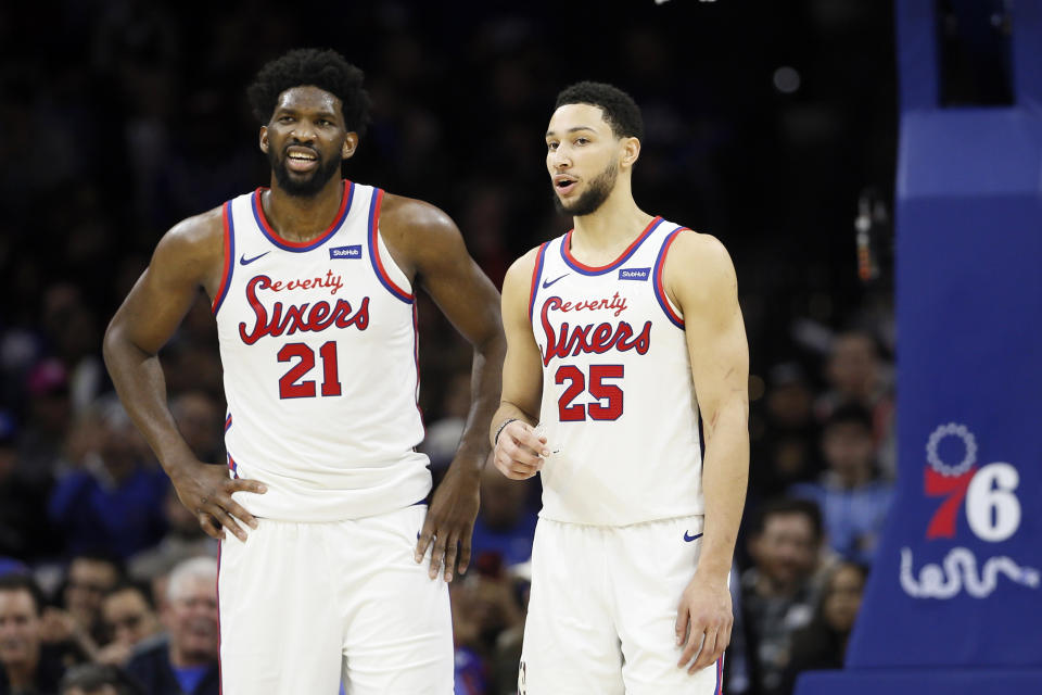 FILE - In this Dec. 13, 2019, file photo, Philadelphia 76ers' Ben Simmons, right, and Joel Embiid talk during an NBA basketball game against the New Orleans Pelicans in Philadelphia. The 76ers new coach Doc Rivers is set to begin his first training camp with the team trying to unlock the potential of All-Stars Ben Simmons and Joel Embiid.(AP Photo/Matt Slocum, File)