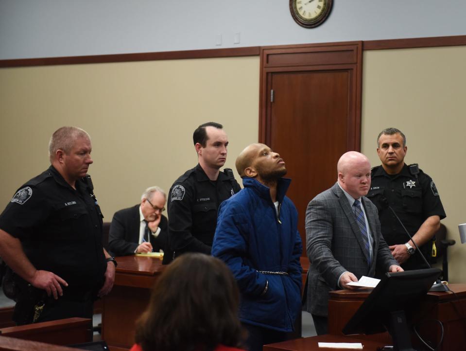 Flanked by Ingham County deputies, convicted murderer Willie Charles Woods, 27, appears in Judge Rosemarie Aquilina's district courtroom for his sentencing hearing. Beside Woods is Public Defender Steven Feigelson.