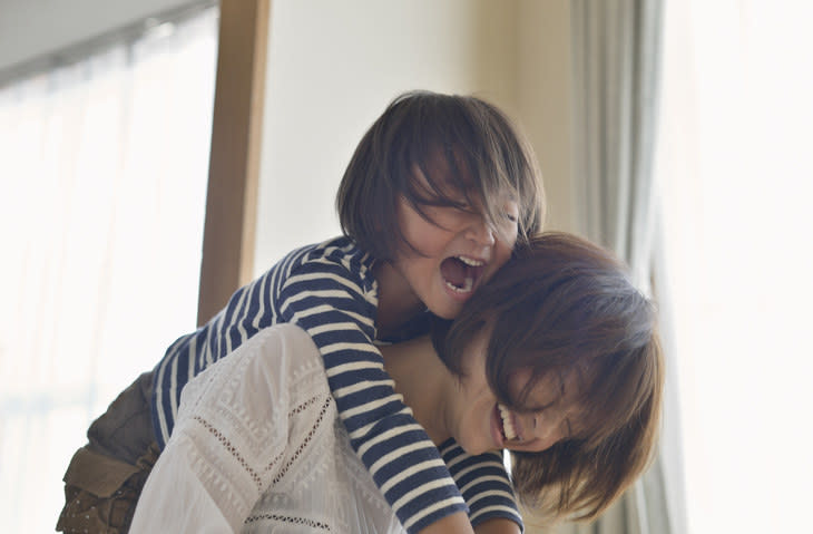 Mother giving daughter a piggyback ride,