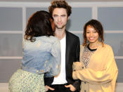 Visitors pose for a photograph with a wax figure of British actor Robert Pattinson in a VIP section of Madame Tussauds London, after being installed for the first time, in London March 25, 2010. REUTERS/Madame Tussauds London/Handout