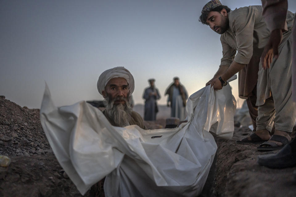 Afghans bury hundreds of people killed in an earthquake to a burial site, outside a village in Zenda Jan district in Herat province, western of Afghanistan, Monday, Oct. 9, 2023. Saturday's deadly earthquake killed and injured thousands when it leveled an untold number of homes in Herat province. (AP Photo/Ebrahim Noroozi)