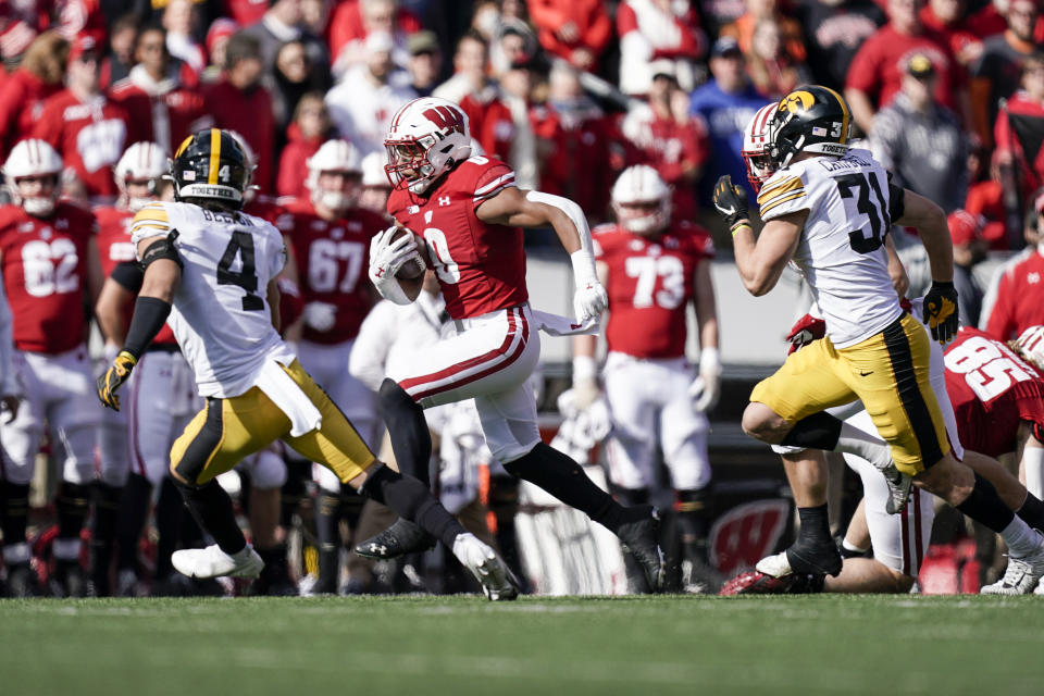 Wisconsin running back Braelon Allen (0) runs as Iowa's defensive back Dane Belton (4) and linebacker Jack Campbell (31) pursues during the second half of an NCAA college football game Saturday, Oct. 30, 2021, in Madison, Wis. Wisconsin upset Iowa 27-7. (AP Photo/Andy Manis)