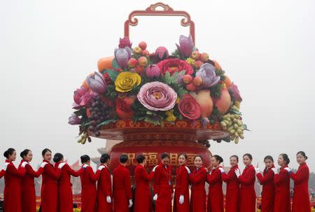 Ushers pose for photos at the Tiananmen Square during the opening of the 19th National Congress of the Communist Party of China at the Great Hall of the People in Beijing, China October 18, 2017. REUTERS/Ahmad Masood