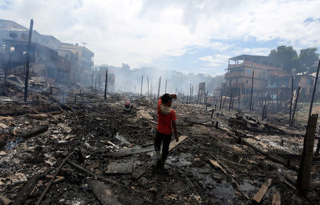 A resident is seen after a fire at Educandos neighbourhood, on a branch of the Rio Negro, a tributary to the Amazon river, in the city of Manaus, Brazil December 18, 2018. REUTERS/Bruno Kelly