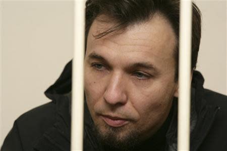 Greenpeace International activist Tomasz Dziemianczuk of Poland, one of 30 people who were arrested over a Greenpeace protest at the Prirazlomnaya oil rig, sits in a defendants' cage during a court session in St. Petersburg, November 19, 2013, in this picture provided by Greenpeace. REUTERS/Igor Podgorny/Greenpeace/Handout via Reuters