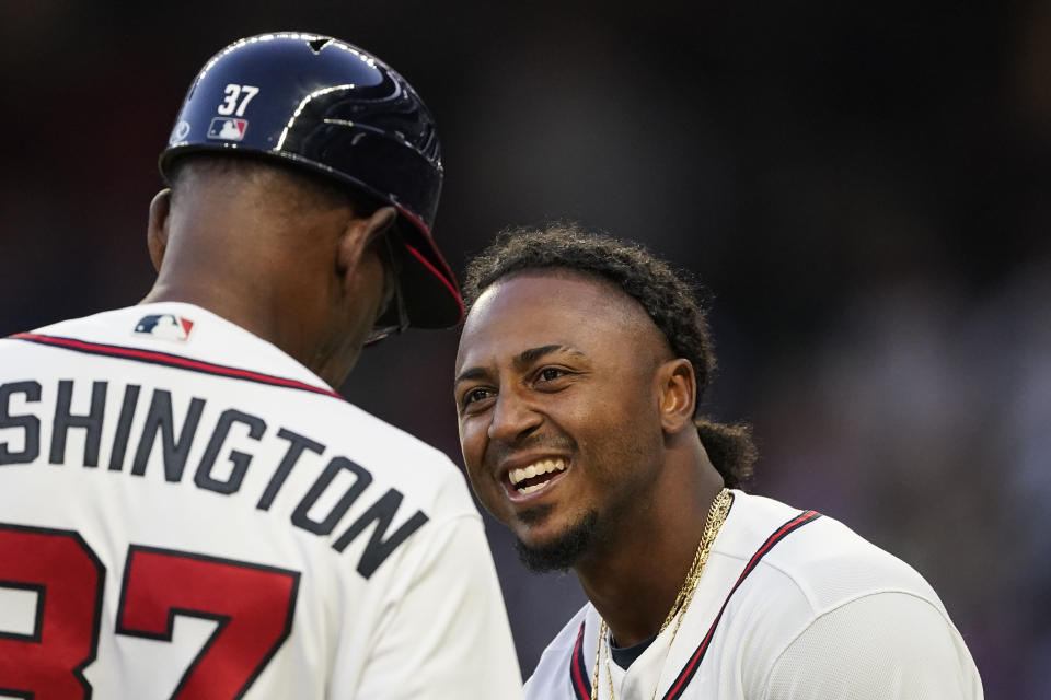 Atlanta Braves second baseman Ozzie Albies (1) laughs with third base coach Ron Washington (37) during the inning of a baseball game against the Chicago Cubs, Tuesday, April 26, 2022, in Atlanta. (AP Photo/Brynn Anderson)