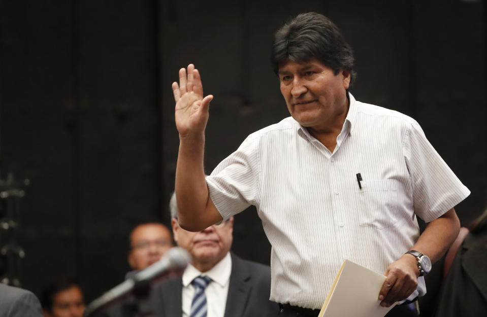 Bolivia's former President Evo Morales waves to reporters as he arrives for a press conference at the Museum of Mexico City, Wednesday, Nov. 13, 2019. Mexico has granted asylum to Morales, who resigned on Nov. 10th under mounting pressure from the military and the public after his re-election victory triggered weeks of fraud allegations and deadly protests. (AP Photo/Marco Ugarte)