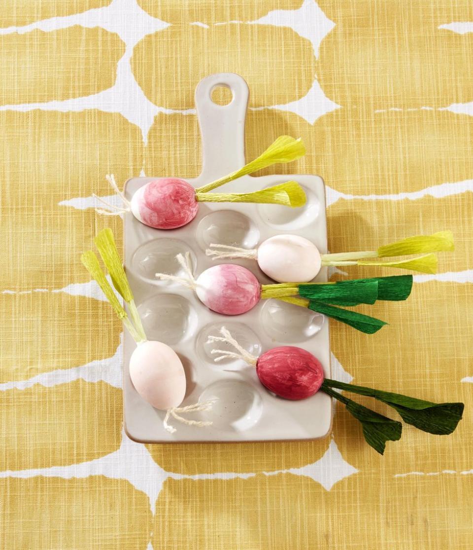 <p>Whip up a batch of eggs that resemble farmer’s market fresh radishes by painting three quarters of a blown-out egg with pink paint. Finish the look by using hot glue to attach off-white twine to the bottom as roots, and rolled-up green crepe paper to the top as a stem.</p>