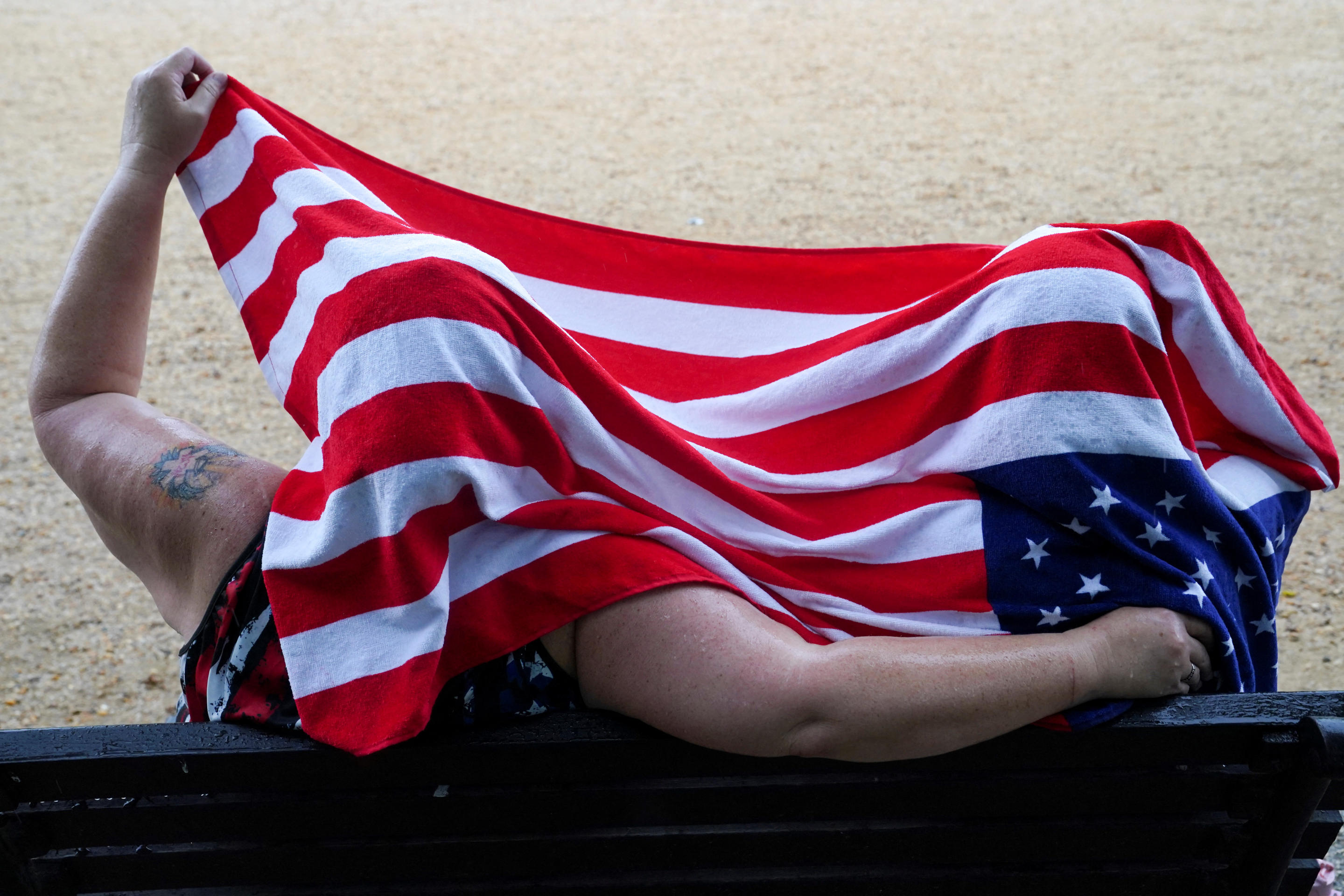 Two people with an American flag towel draped over their heads.