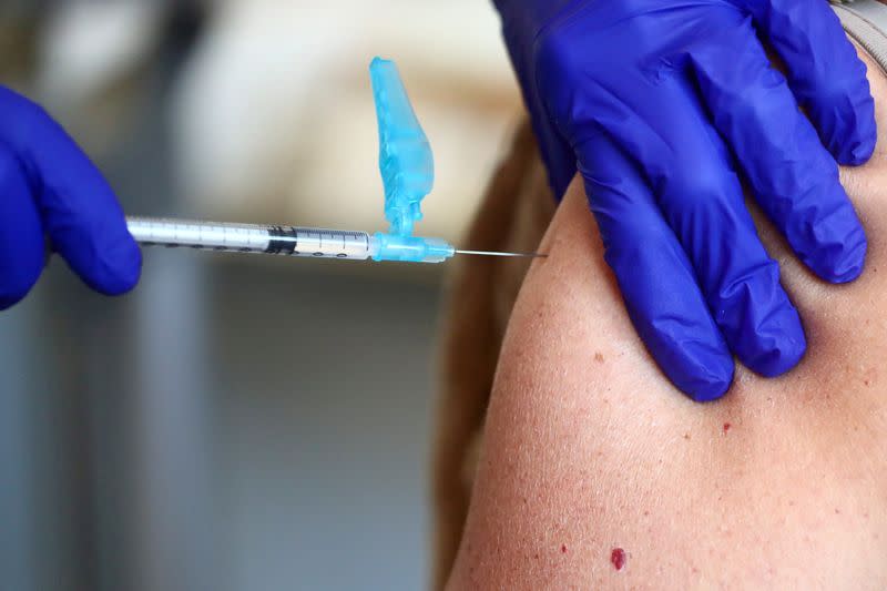 FILE PHOTO: Health worker receives an injection with a dose of the Pfizer-BioNTech COVID-19 vaccine, in Madrid