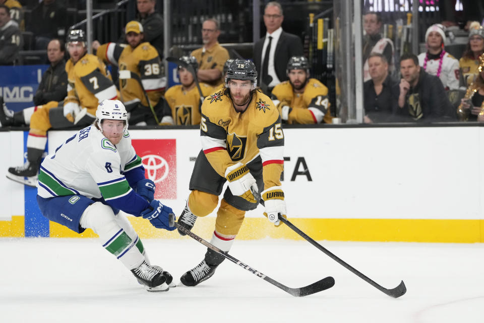 Vegas Golden Knights defenseman Noah Hanifin (15) passes the puck against Vancouver Canucks right wing Brock Boeser (6) during the first period of an NHL hockey game Thursday, March 7, 2024, in Las Vegas. (AP Photo/Lucas Peltier)