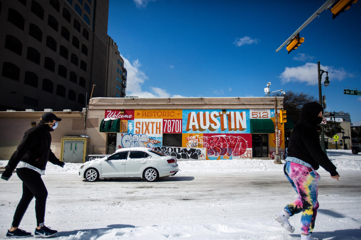 Pedestrians walk along a snow-covered street on Feb. 15, in Austin, Texas. Winter storm Uri has brought historic cold weather to the state. (Montinique Monroe/Getty Images)