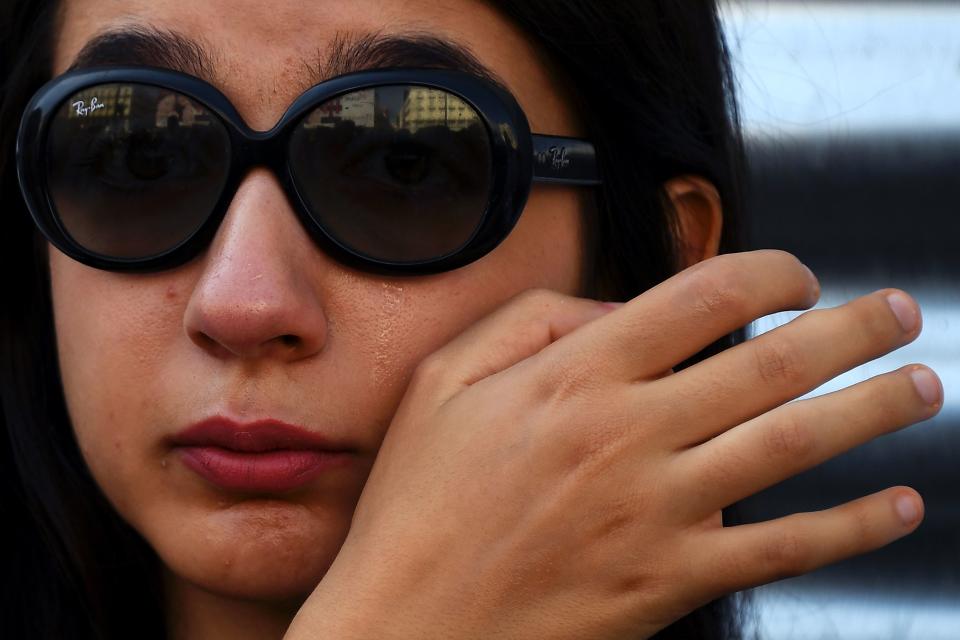 A woman cries as she observes a minute of silence in Puerta del Sol, Madrid, for the victims of Thursday's twin attacks in Spain.