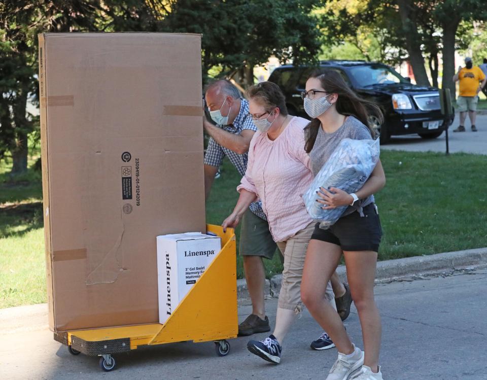 Freshman Makenna Mohr, right, of Green Bay and her parents, Dale Mohr, left, and Donica Mohr, help her move her belongings into the UW-Milwaukee's Sandburg Residence Hall.