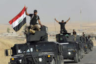 Irakische Spezialeinsatzkräfte fahren auf ihren Kampffahrzeugen in Richtung der irakischen Stadt Mossul. (Bild: Khalid Mohammed/AP)