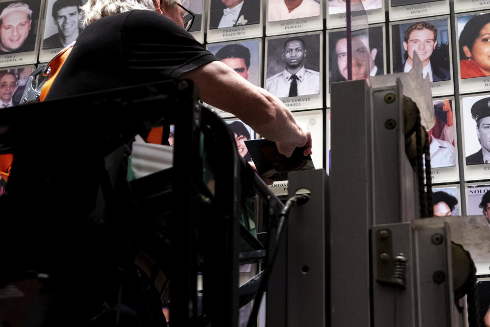 Randolph Black replaces a oak leaf picture with a portrait of Antonio Dorsey Pratt in the 9/11 Memorial & Museum on Wednesday, June 29, 2022 in New York. Pratt's portrait was the last one hung in the museum. (AP Photo/Julia Nikhinson)