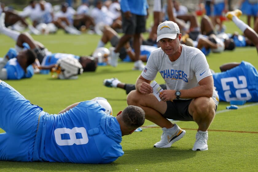 Los Angeles Chargers head coach Brandon Staley, right, talks to outside linebacker Kyle Van Noy (8) during the NFL football team's training camp, Wednesday, July 27, 2022, in Costa Mesa, Calif. (AP Photo/Ringo H.W. Chiu)