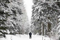 A man walks through a winter landscape after snow fall near Altenberg, Germany, Sunday, Feb. 7, 2021. (AP Photo/Matthias Schrader)